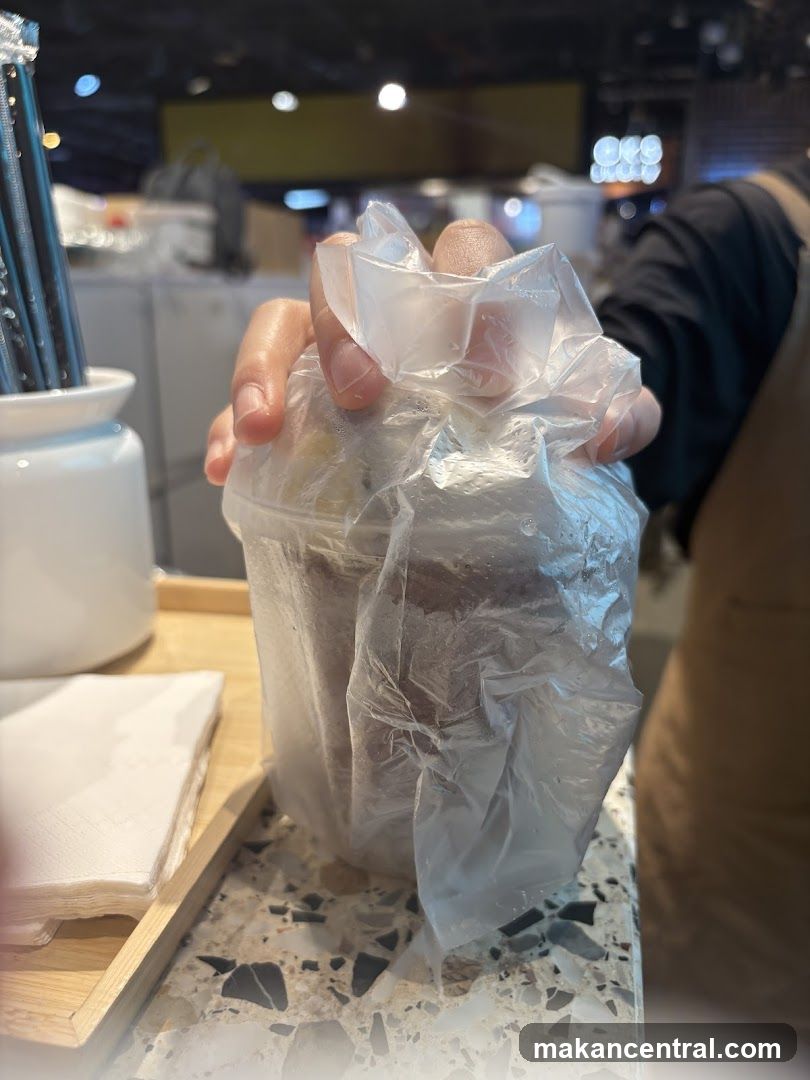 Hand holding a drink in a plastic bag