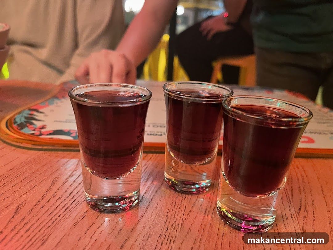Three shots of dark liquid on a table