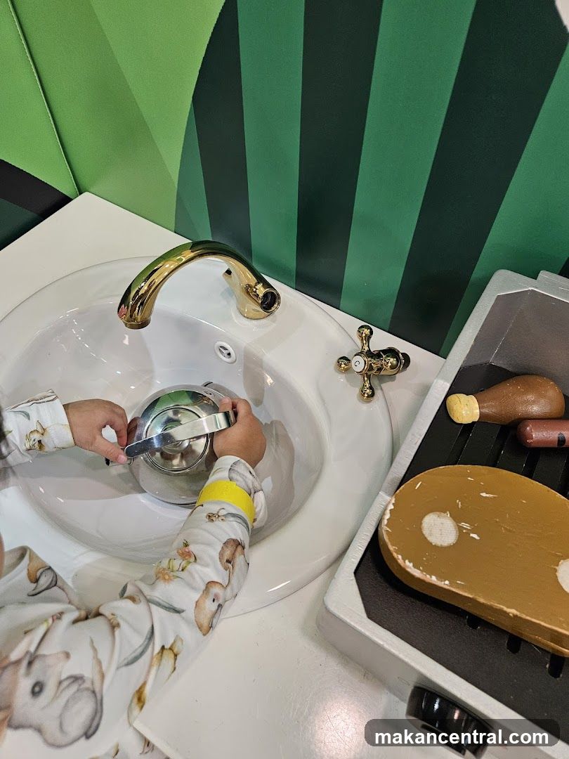Child playing with toy sink and grill