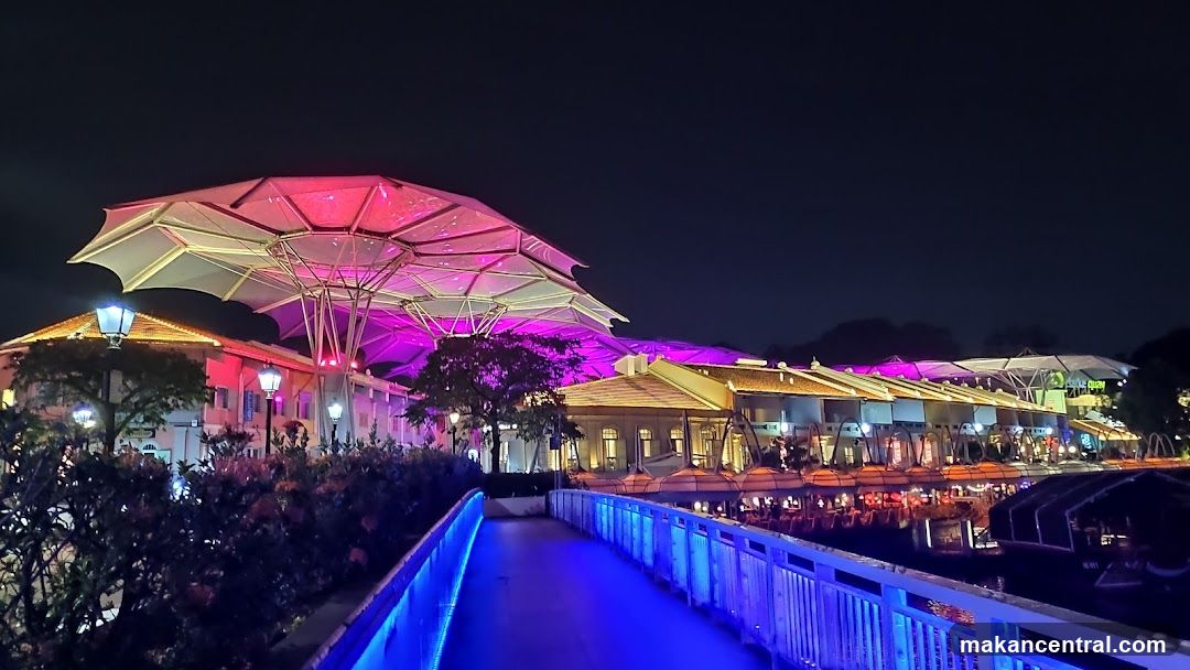Night view of a waterfront promenade with illuminated structures
