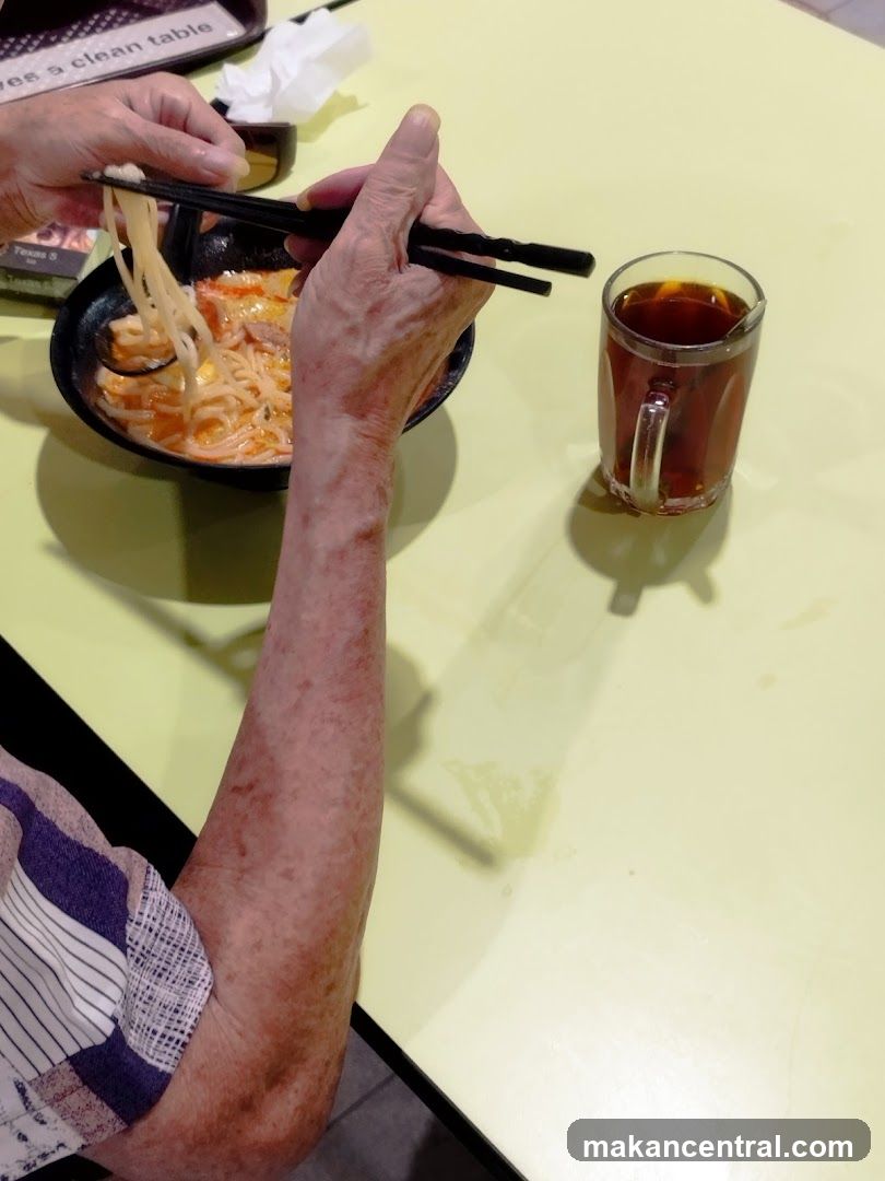 Person eating noodles with chopsticks