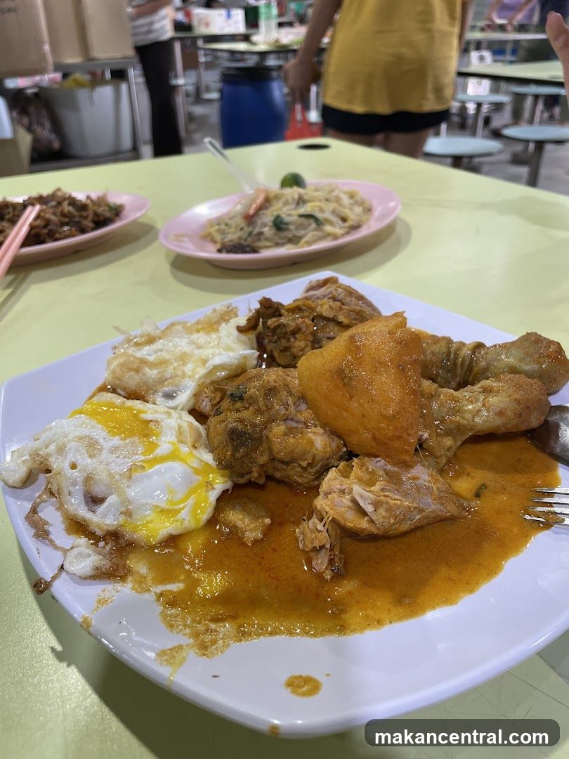 Plate of Curry Chicken with Fried Eggs and Noodles