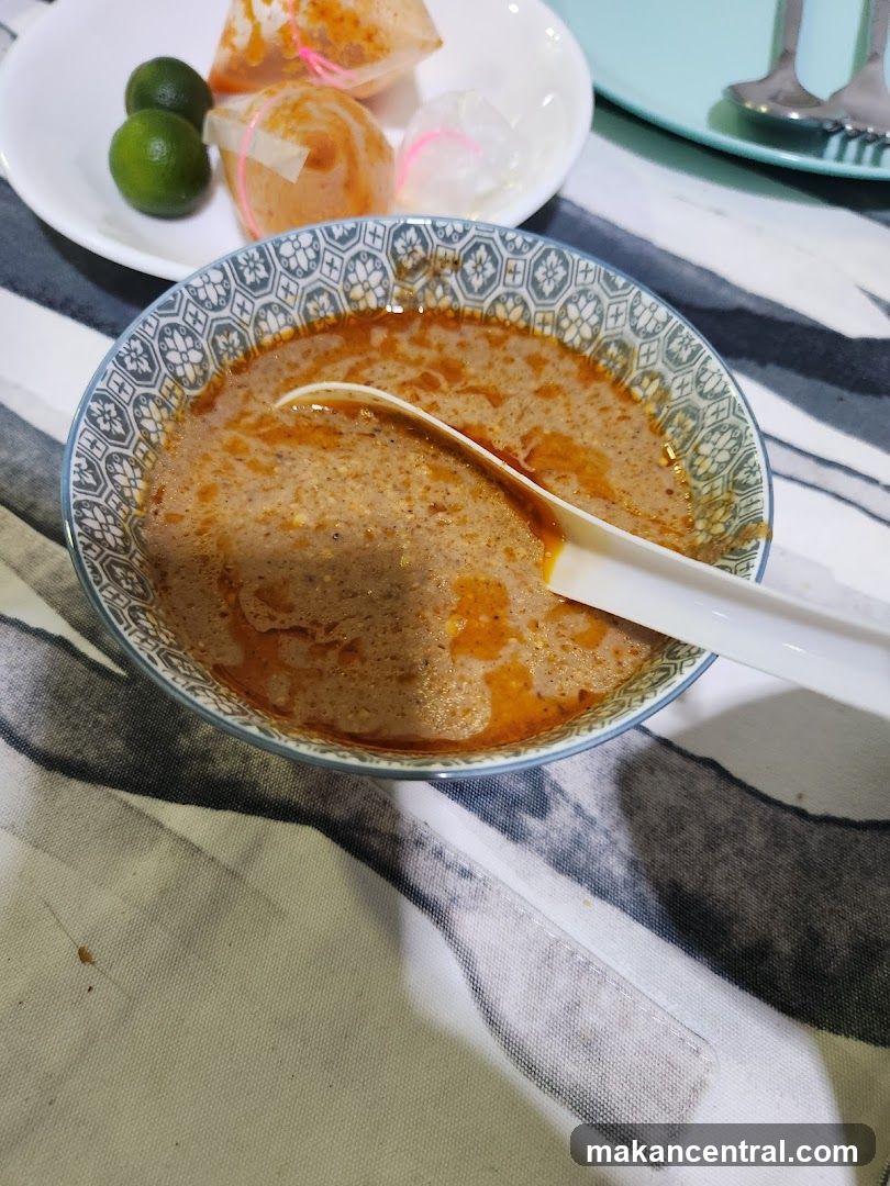 Bowl of Laksa with Limes and Condiments