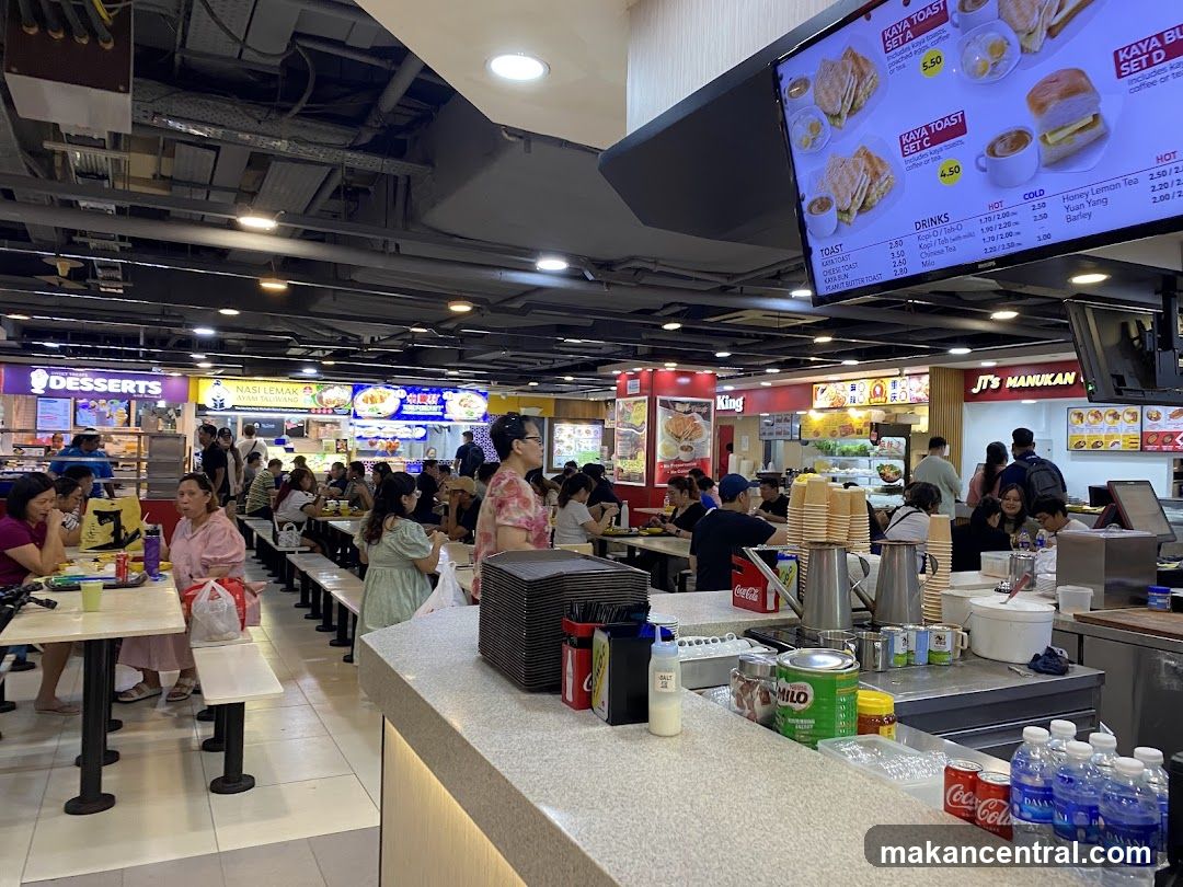 Food court with various stalls and seating areas