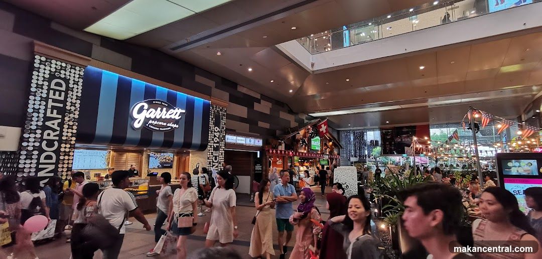 Busy indoor marketplace with various food stalls