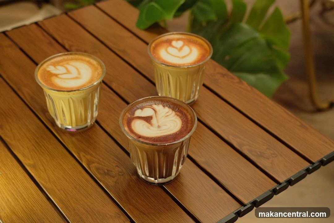 Three coffees with latte art on a wooden table