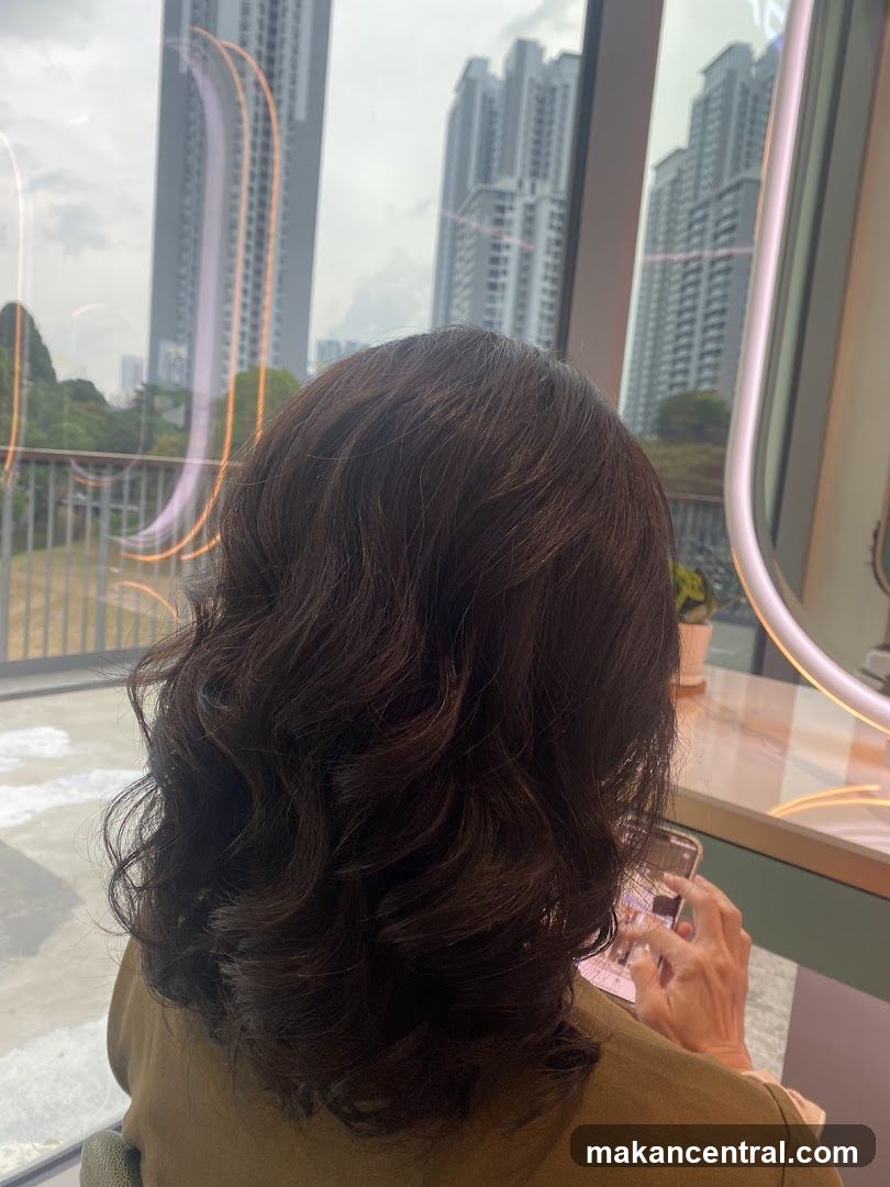 Woman with dark wavy hair looking at phone