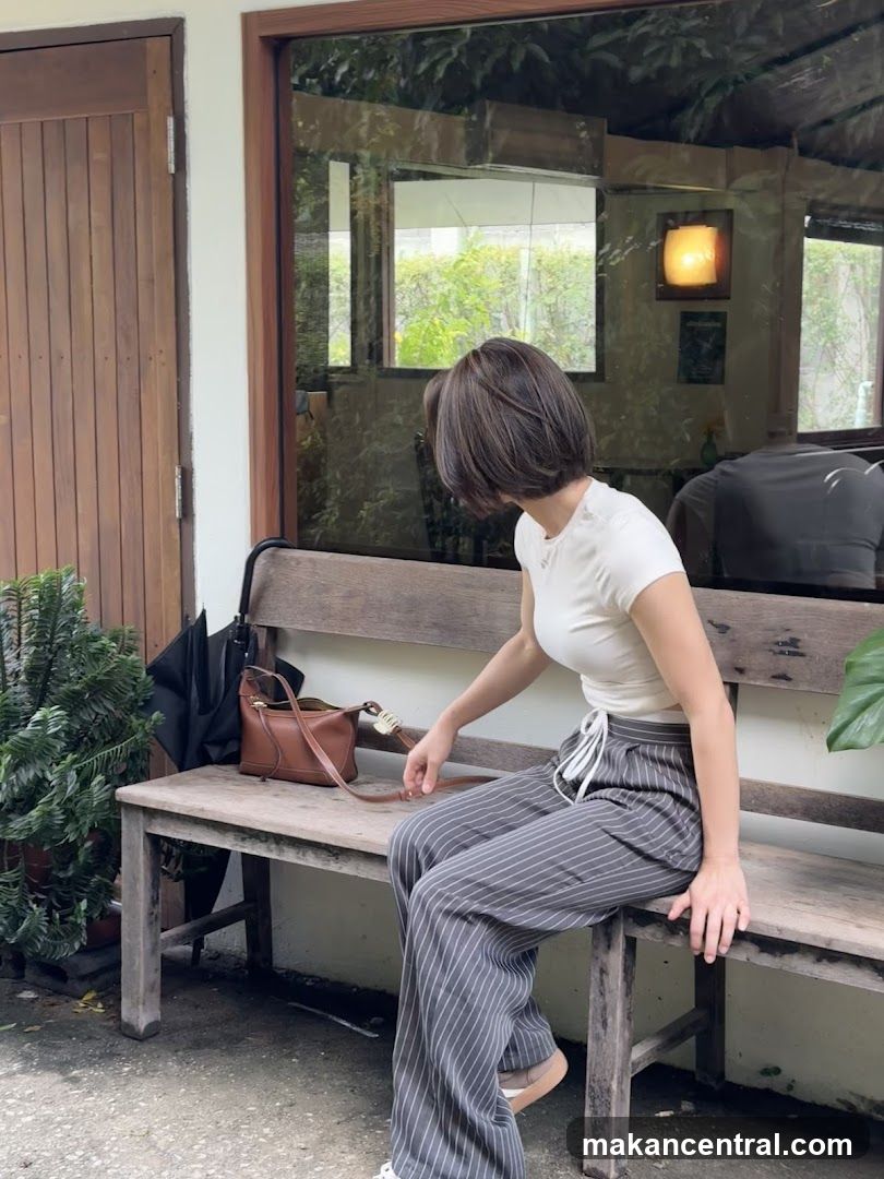 Woman Sitting on a Bench Outside a Cafe