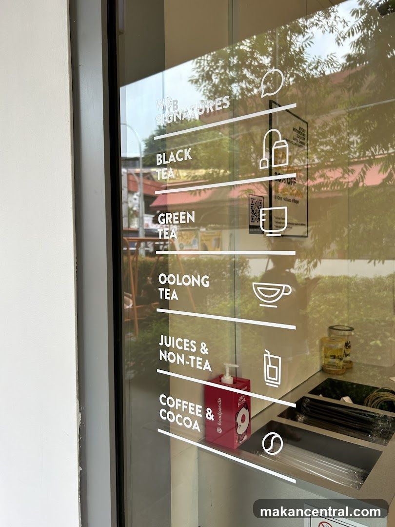 A glass door with white text listing drink categories and icons. Categories include WBB Signatures, Black Tea, Green Tea, Oolong Tea, Juices & Non-Tea, and Coffee & Cocoa. A foodpanda dispenser and straws are visible inside.