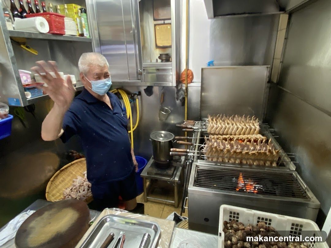 Man Waving in Kitchen with Roasting Chicken Wings