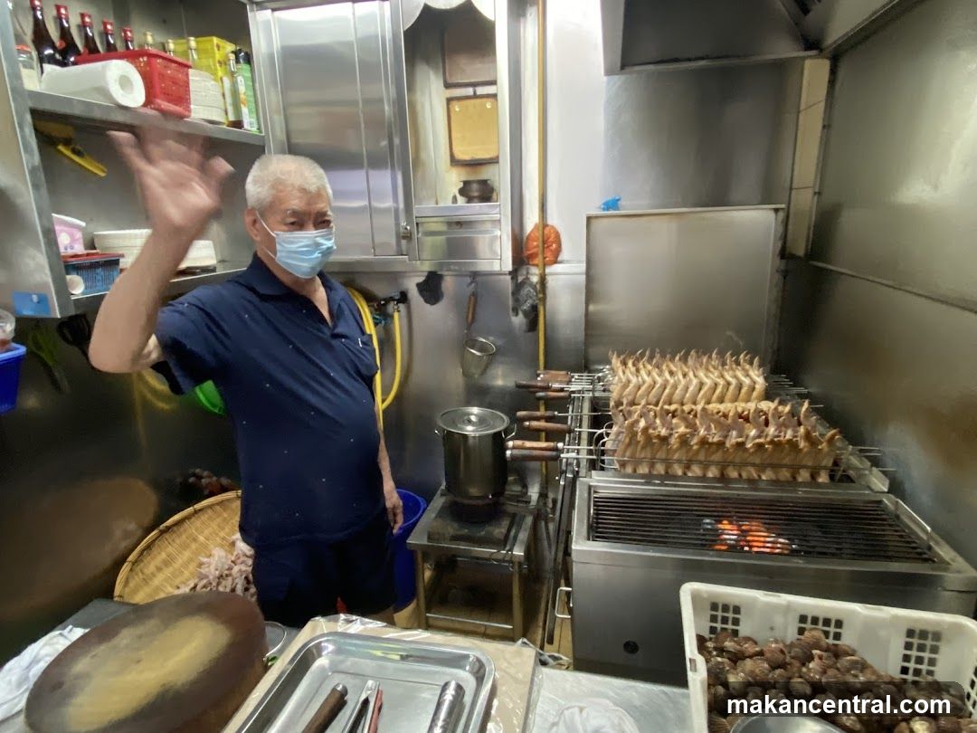 Man Waving in Kitchen with Roasting Chicken Wings