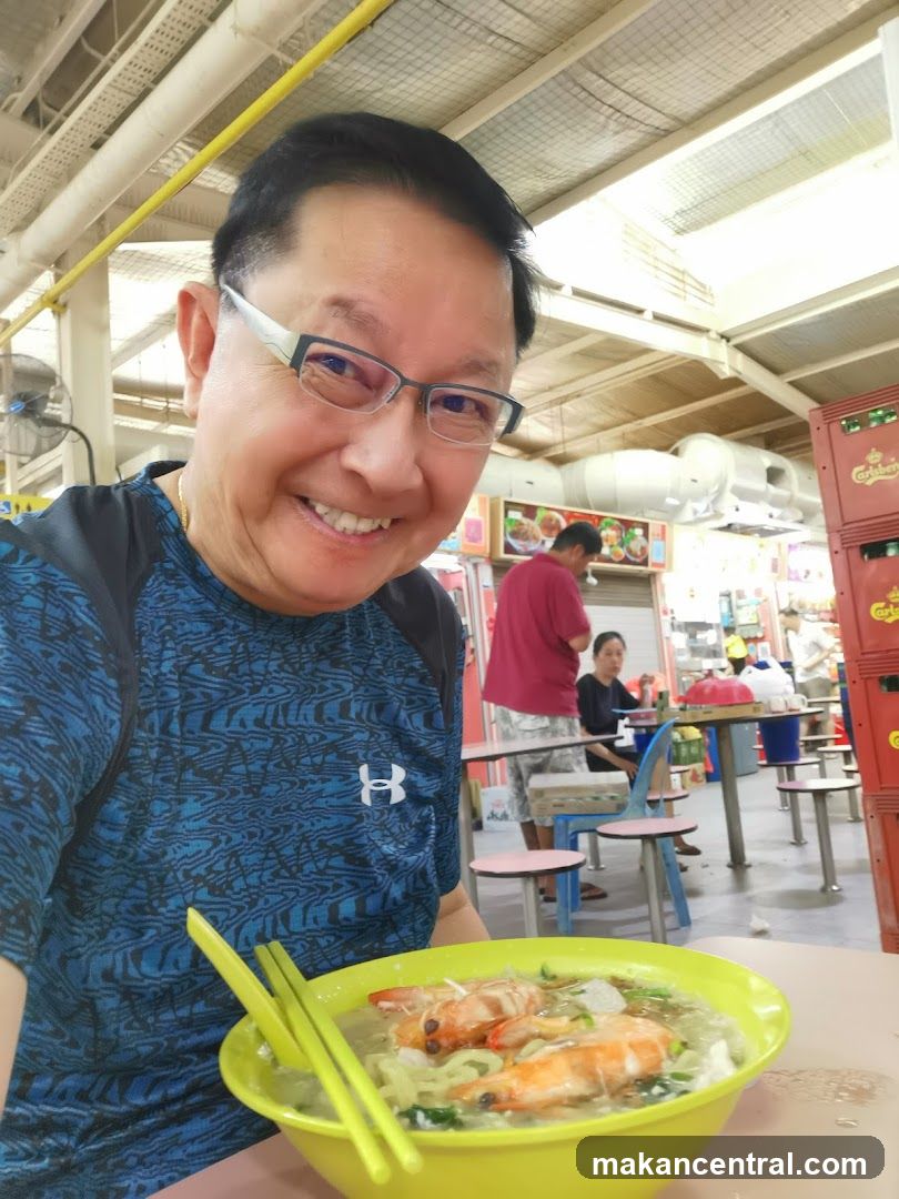 Man with a bowl of prawn noodles