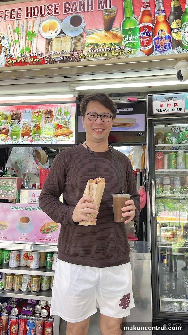 Man Holding Banh Mi and Drink