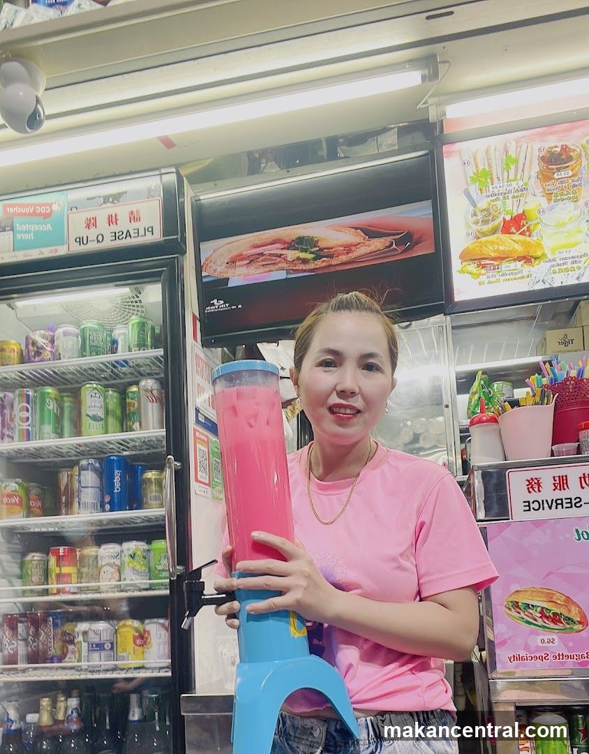 Woman holding a large pink drink dispenser