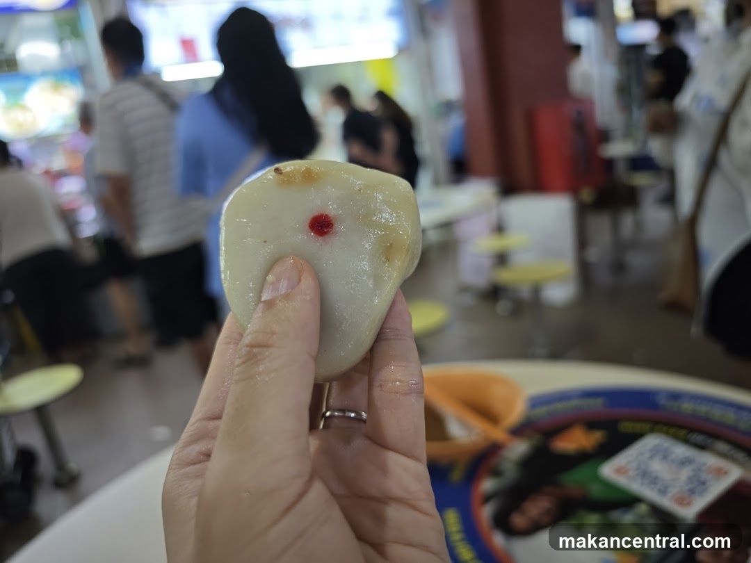 Hand holding a food item with red dot