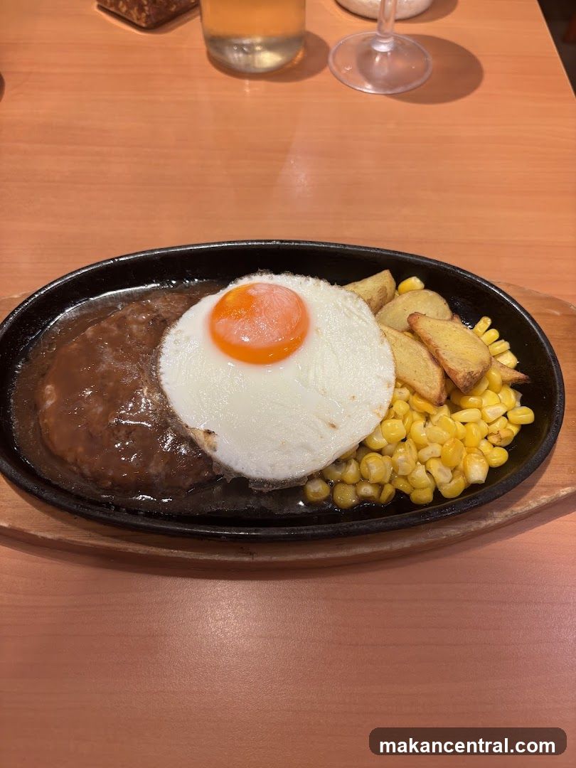 Hamburger steak with fried egg, corn, and potato wedges