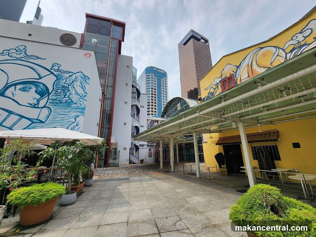 Outdoor seating area with murals and modern buildings