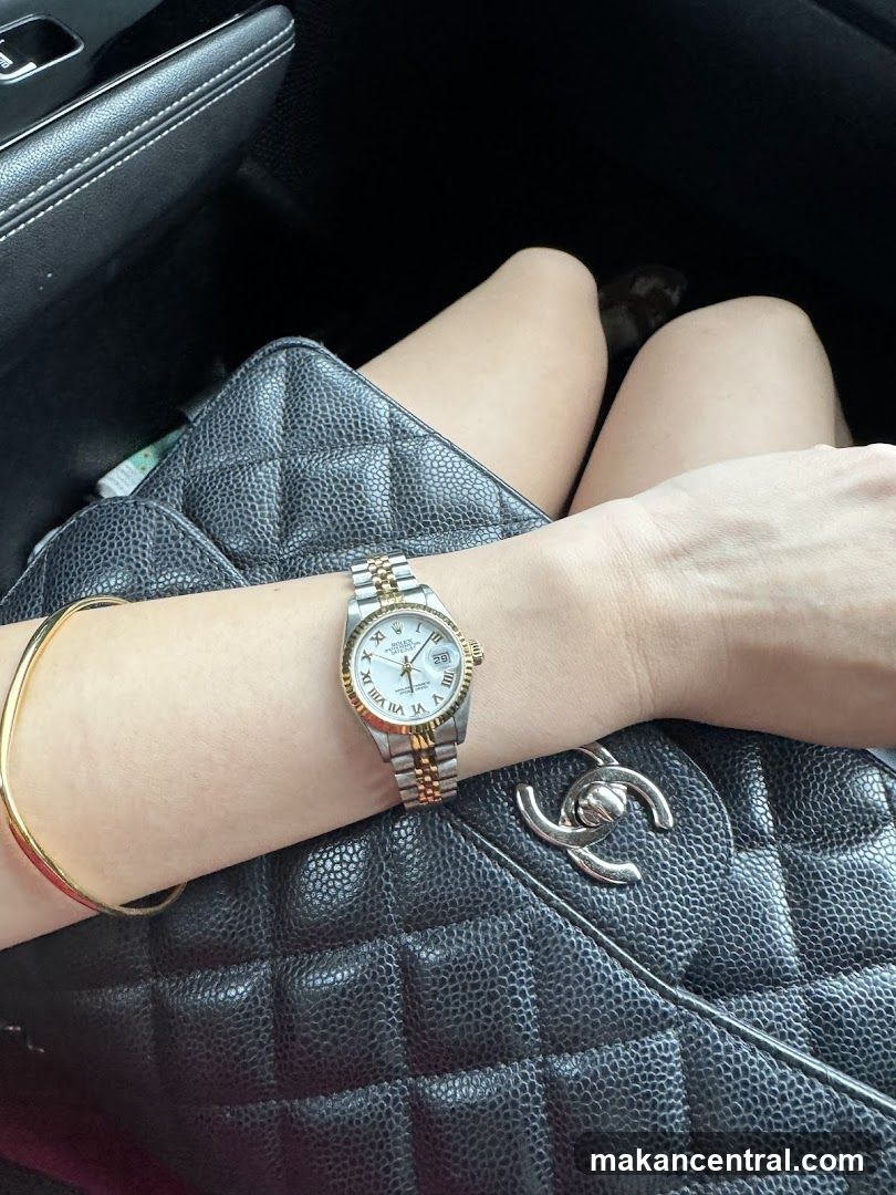 Woman wearing a Rolex watch and gold bracelet
