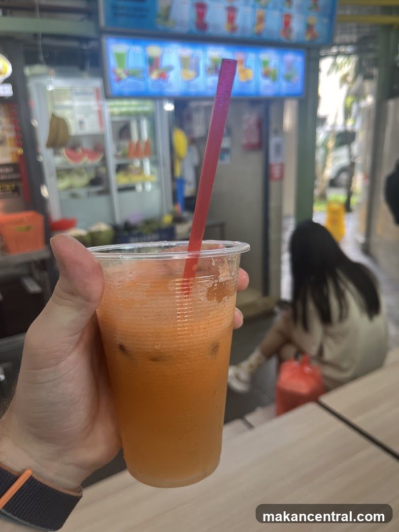 Person holding a drink in front of a juice stall