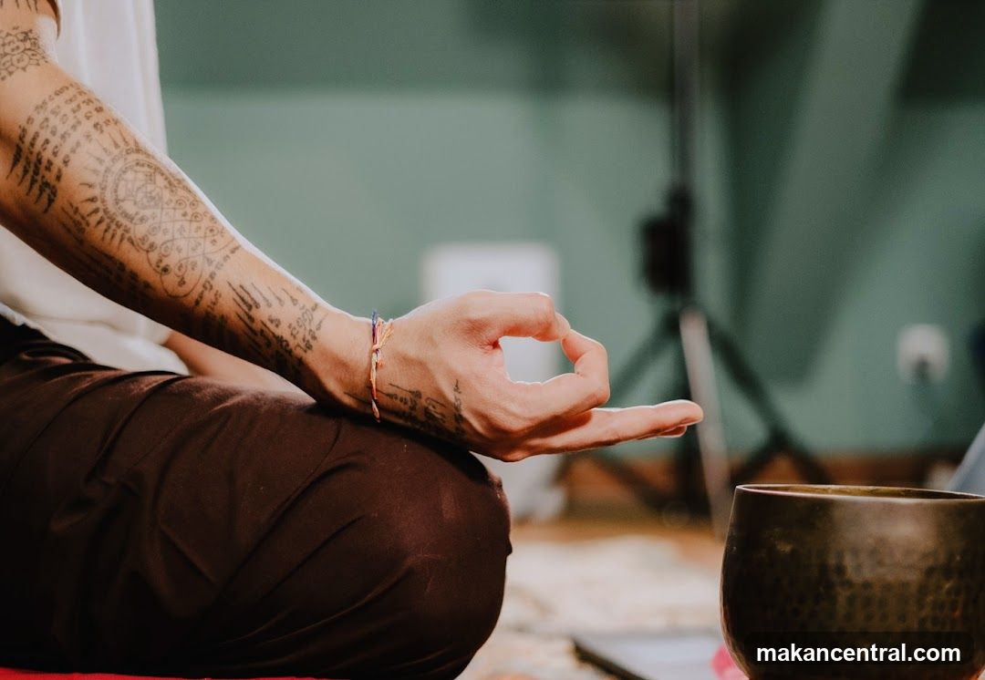 Person meditating with tattoos
