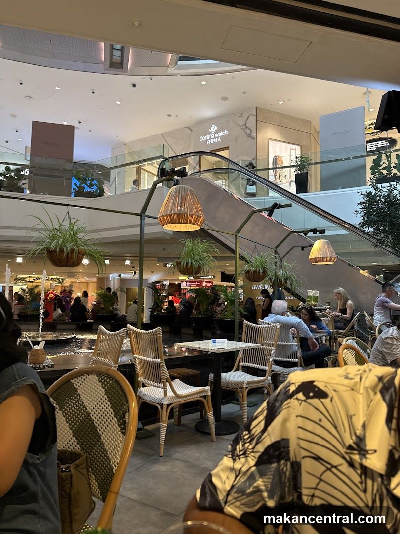 Indoor mall dining area with escalators and shops