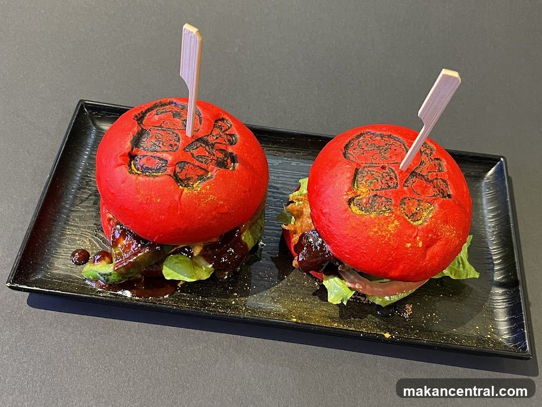 Two red burgers on a black plate