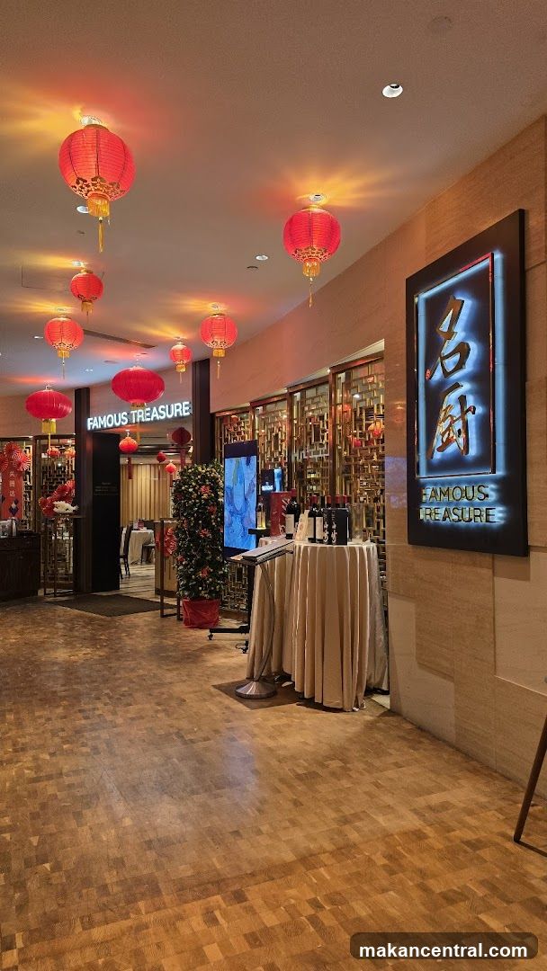 The entrance to Famous Treasure restaurant is decorated with red lanterns. A large sign with the restaurant's name is visible. Inside, tables are set for dining.