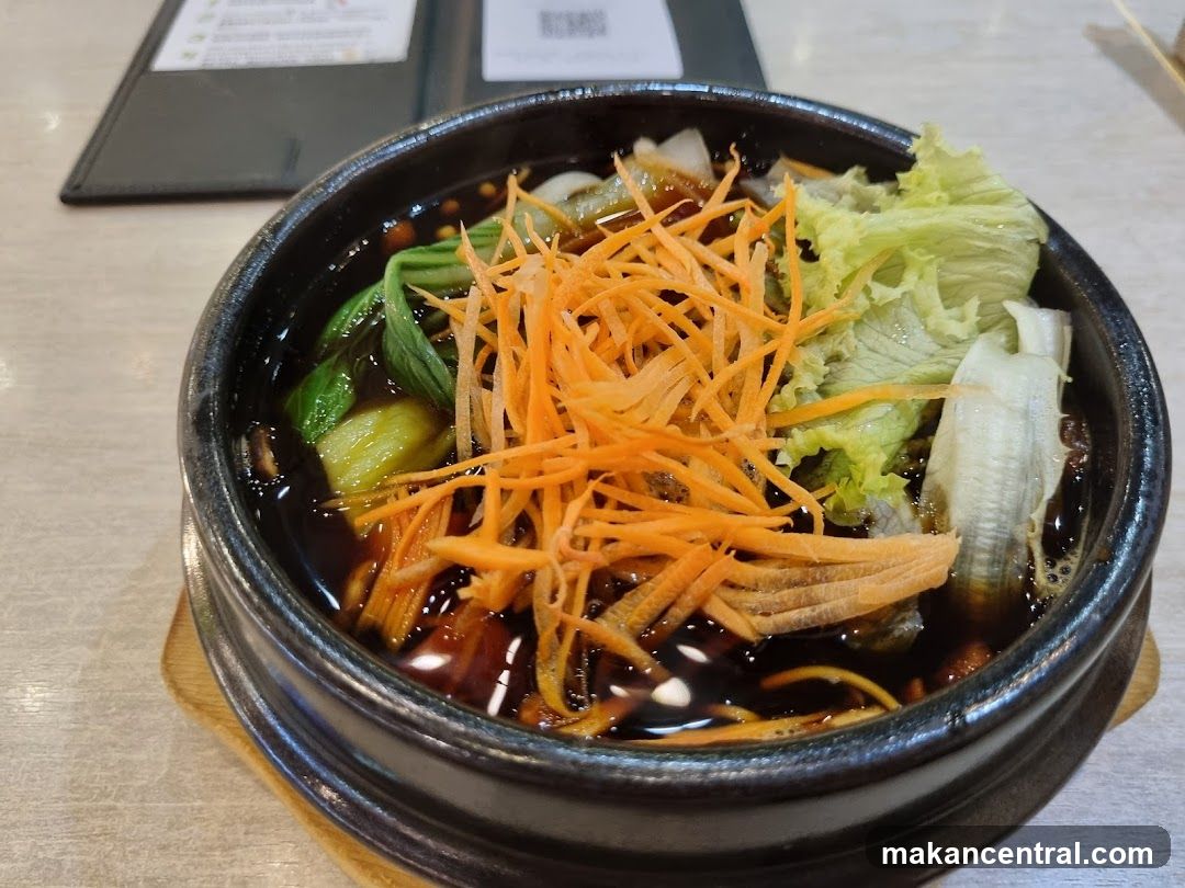 Bowl of food with shredded carrots and lettuce