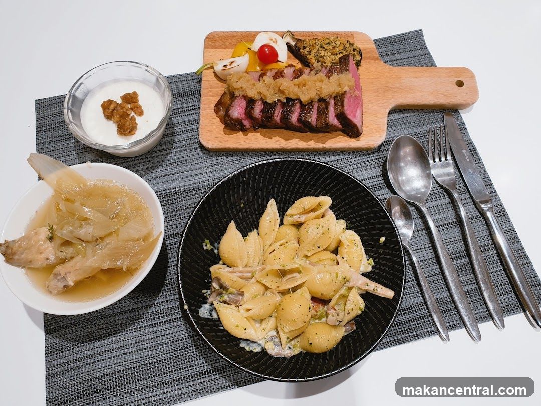 A meal with steak, pasta, and soup