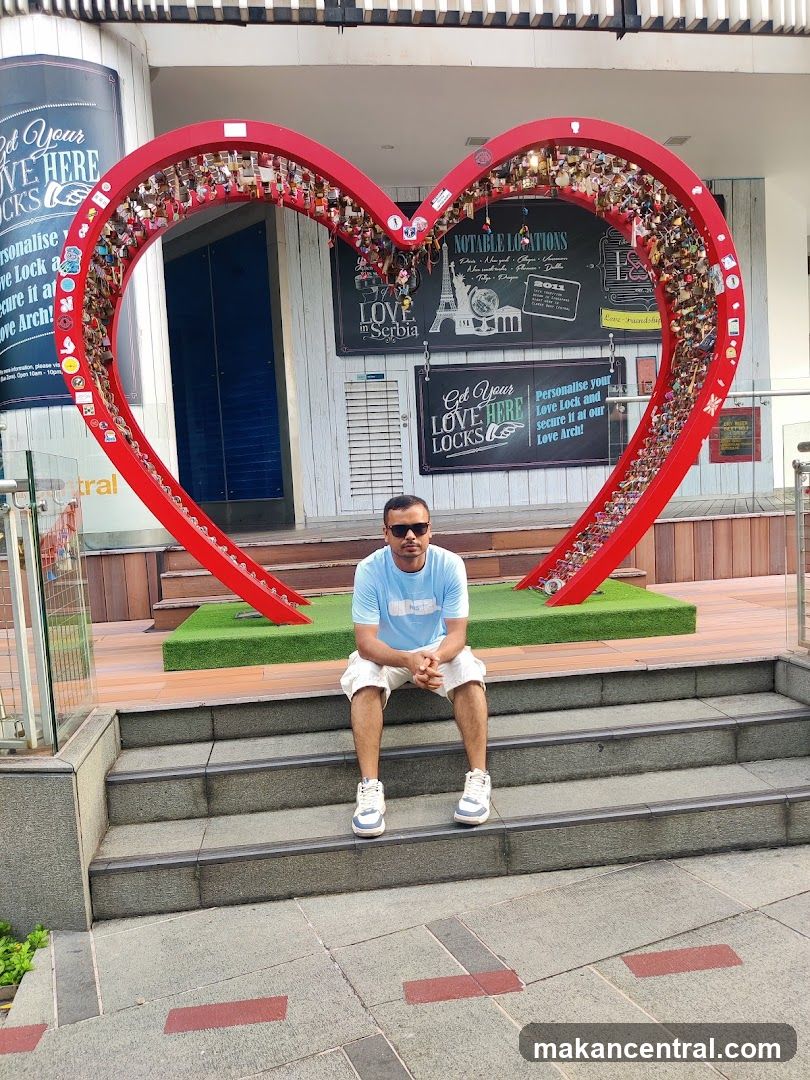 Man Sitting in Front of a Heart Sculpture