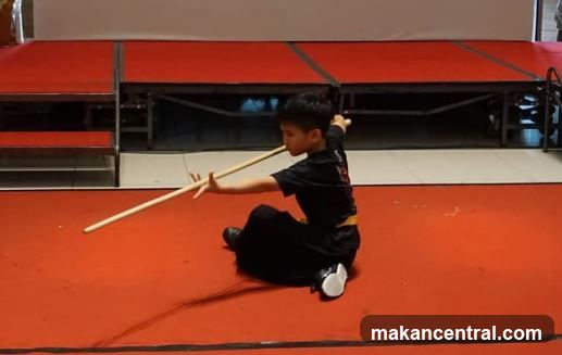 Young boy practicing martial arts with a staff
