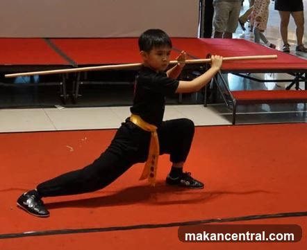 Child practicing martial arts with a staff