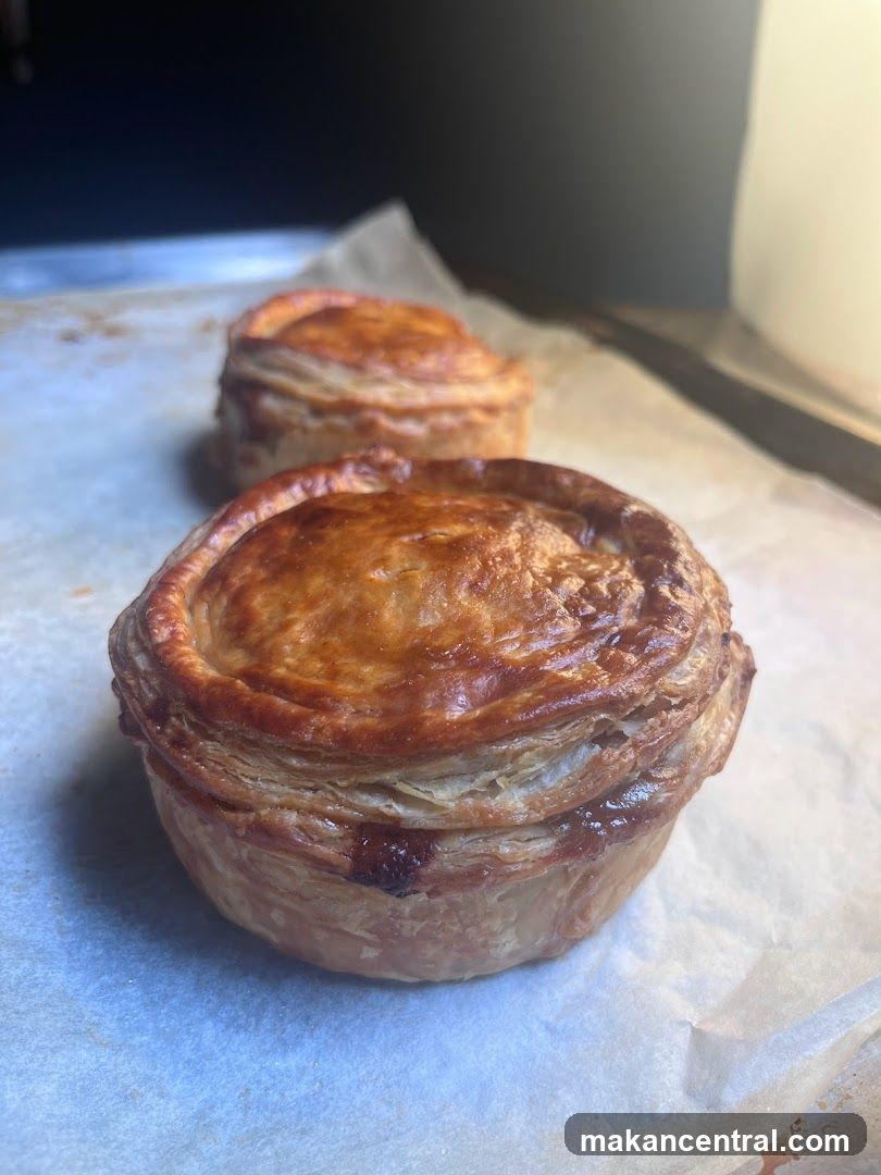 Two golden-brown pies on parchment paper