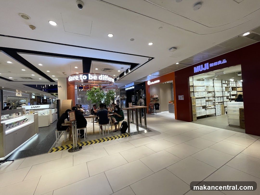 Indoor mall scene with shops and seating area