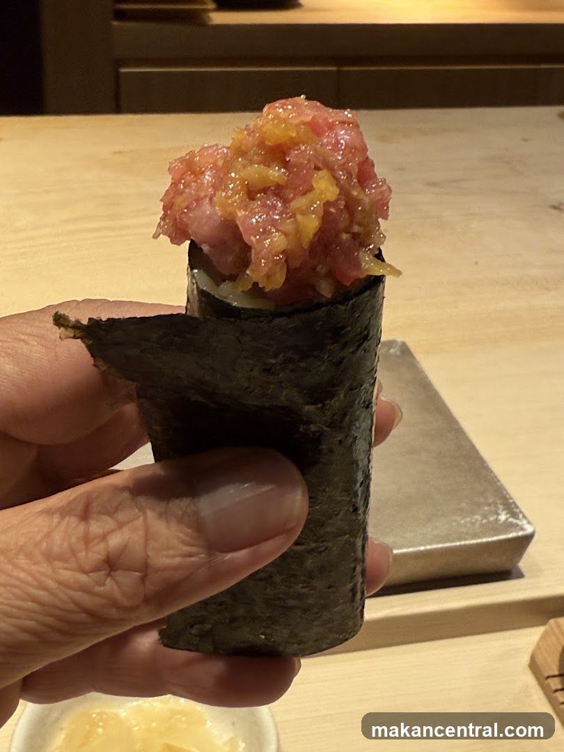 Hand holding a piece of sushi