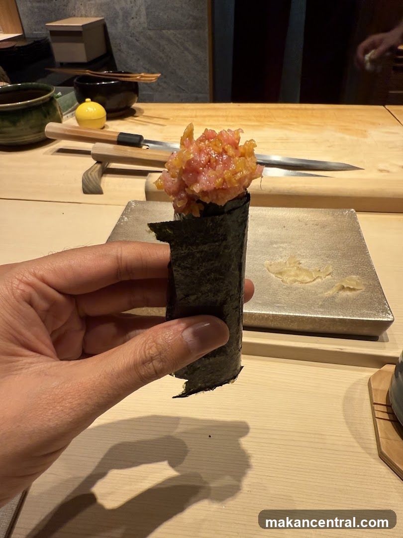 Hand holding a tuna hand roll