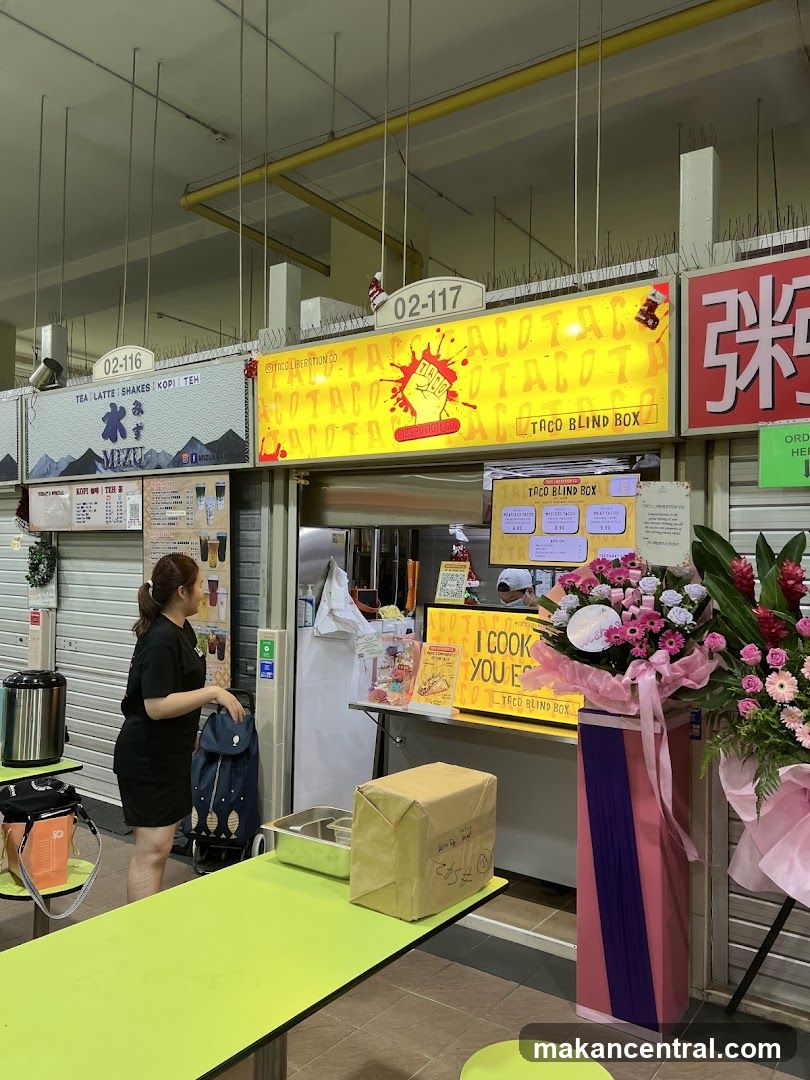 Food stall with signage and a woman