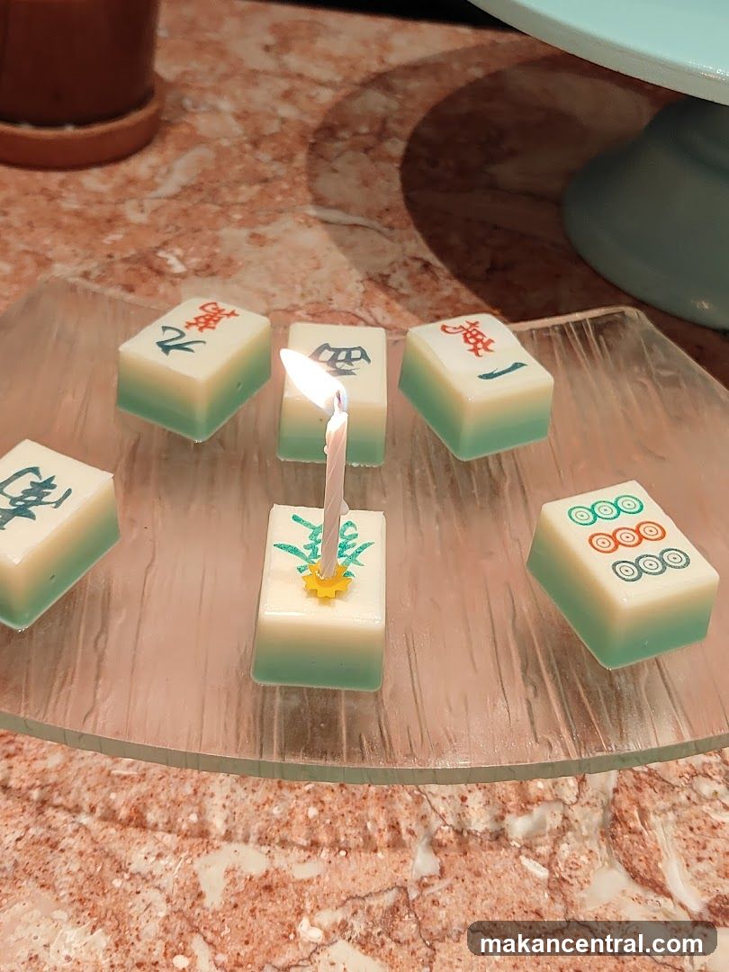 Mahjong-themed dessert with a birthday candle