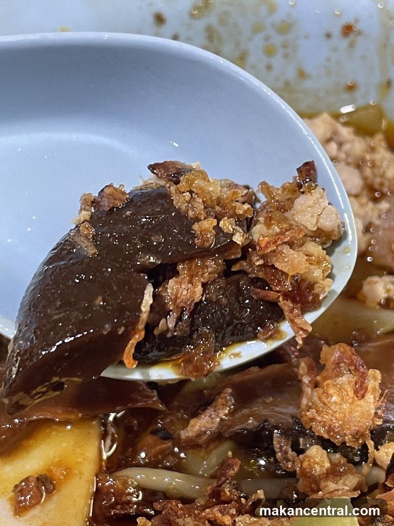 Close-up of a Spoonful of Braised Pork Belly and Mushrooms