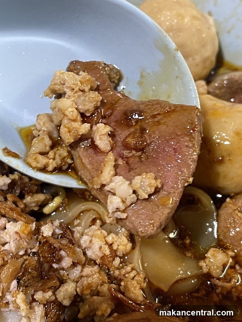 Close-up of a bowl of noodles with meat and meatballs