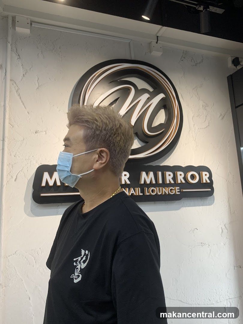 Man in front of a salon sign