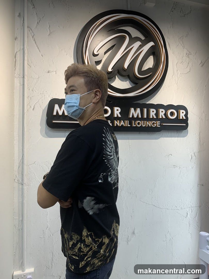 Man in front of salon sign