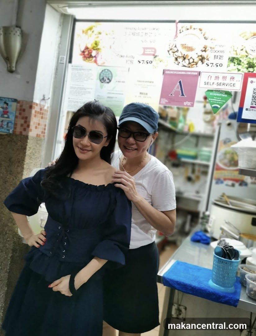 Two Women Posing in Front of a Food Stall