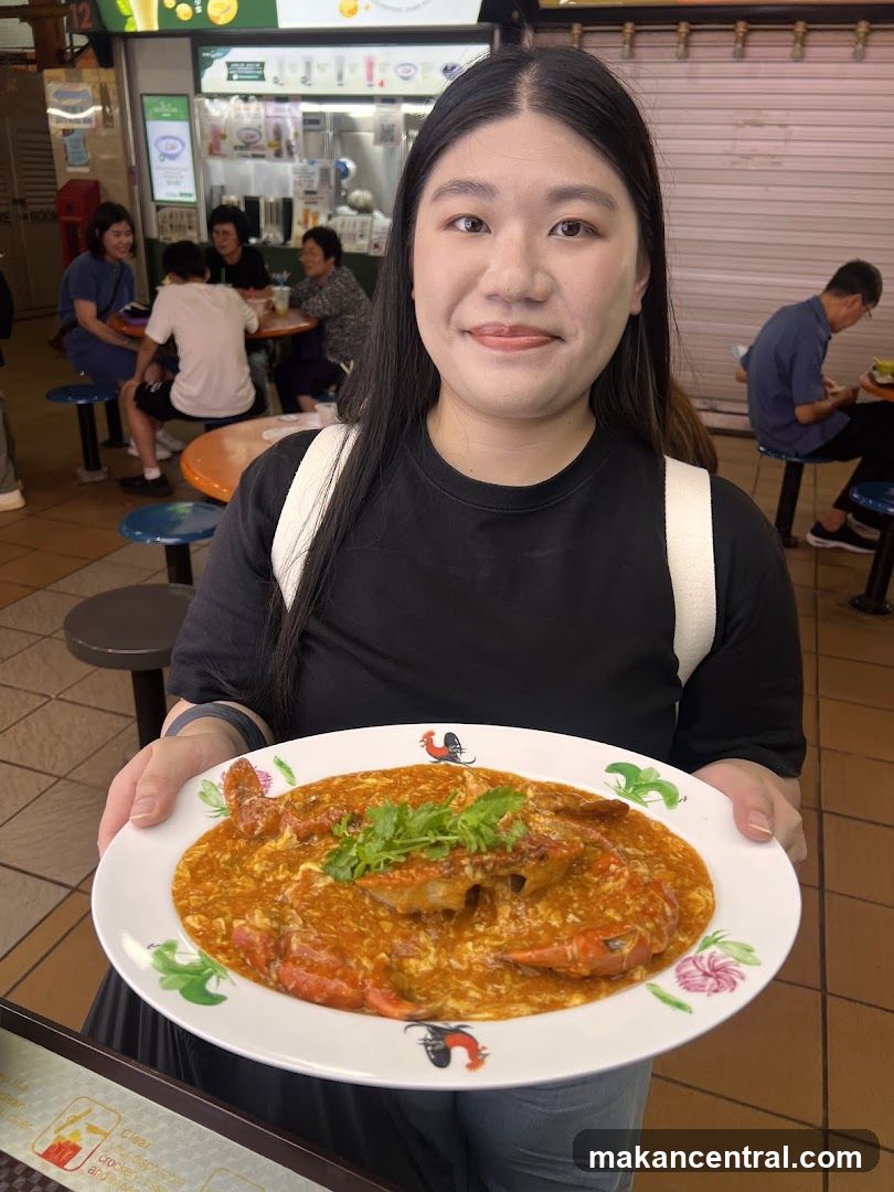 Woman holding a plate of chili crab