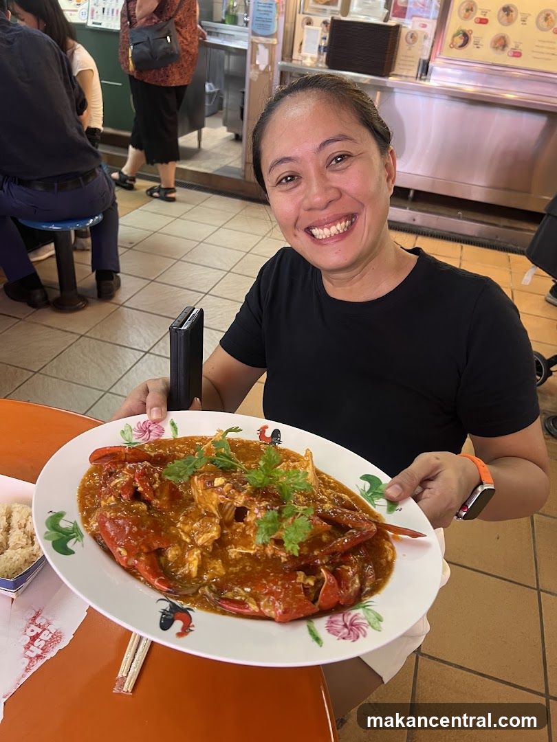 Woman holding a plate of chili crab