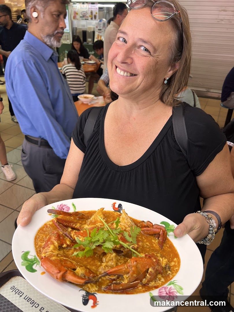Woman holding a plate of chili crab