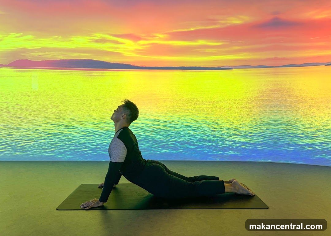 Man practicing yoga in cobra pose with vibrant sunset backdrop