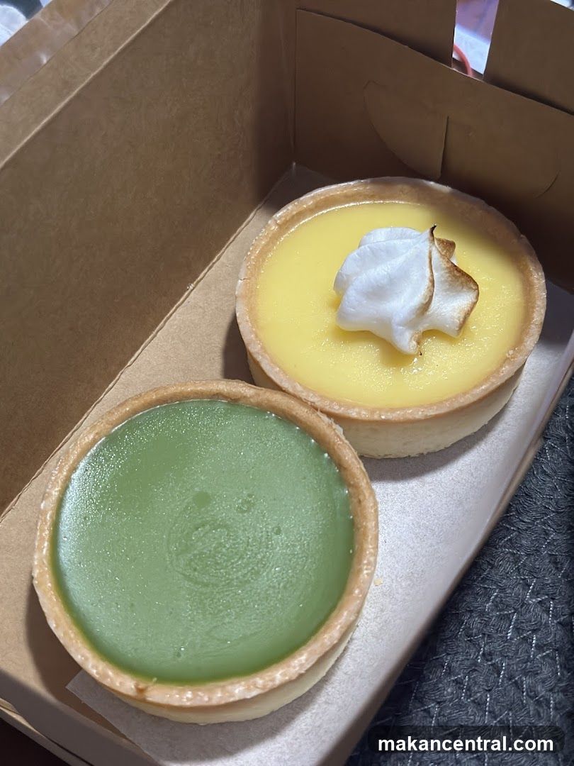 Two tart desserts in a cardboard box
