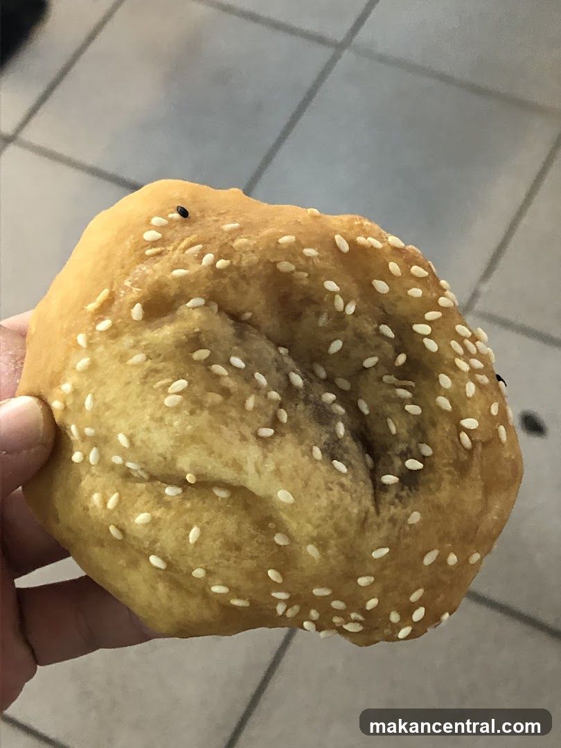 Hand holding sesame-topped pastry