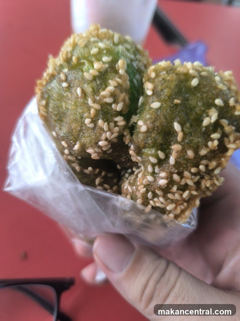 Hand holding sesame-coated green food item